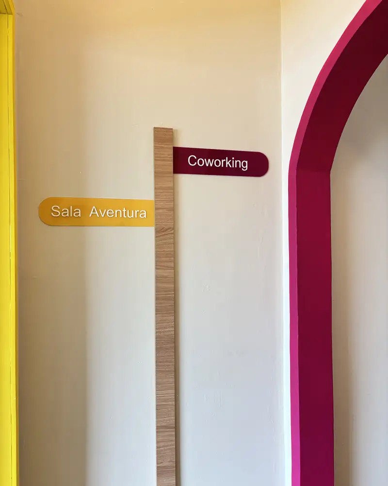 Corredor com arco magenta e placas das salas
