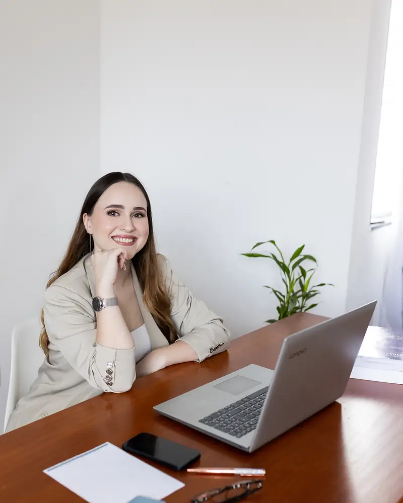 Profissional da equipe sorrindo em uma mesa com notebook
