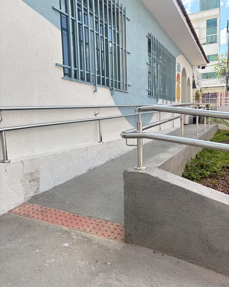 Fachada azul da clínica com rampa de acesso e corrimão