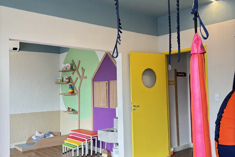 Sala com porta amarela de visor redondo, que permite à família acompanhar